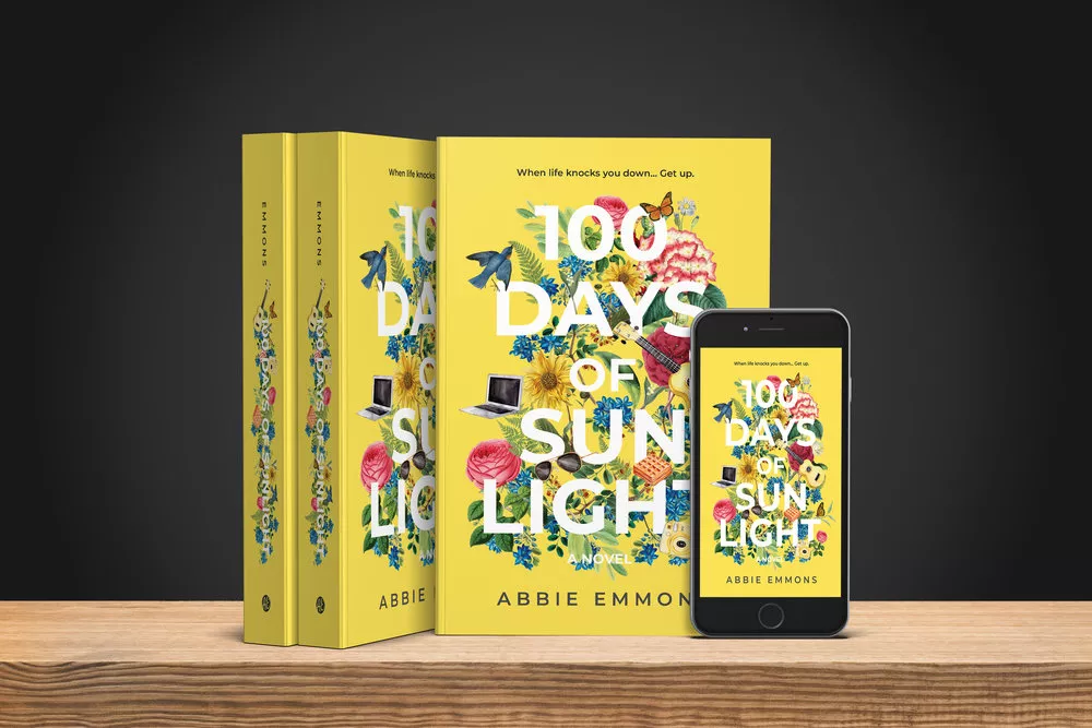 Three copies of 100 Days of Sunlight by Abbie Emmons sit on a table against a dark background, with a smartphone showing the cover in the bottom right.